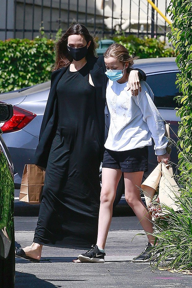 Angelina Jolie without make-up and without a bra walks hugging her daughter Vivienne