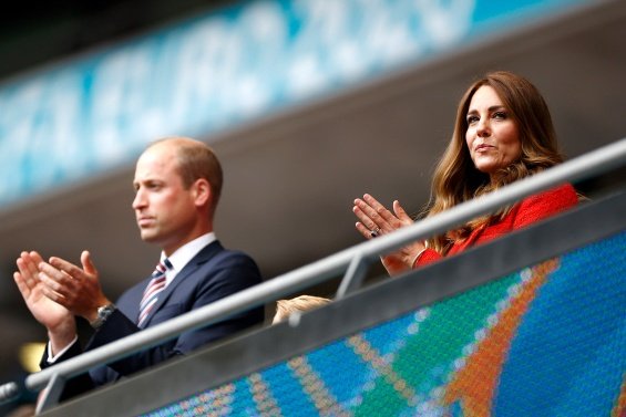 Duchess Catherine and Prince William with little Prince George at a football match