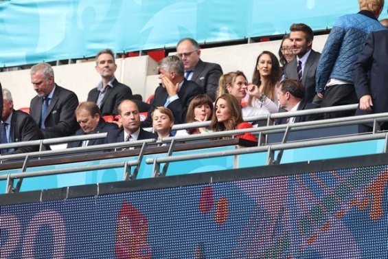 Duchess Catherine and Prince William with little Prince George at a football match