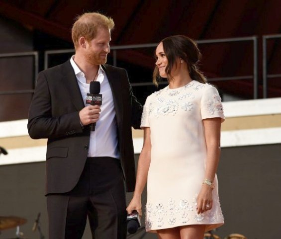 Meghan Markle in a white creation from Valentino next to Prince Harry at an event in New York