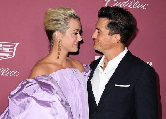 Katy Perry in a voluminous creation next to Orlando Bloom at the Power of Women event