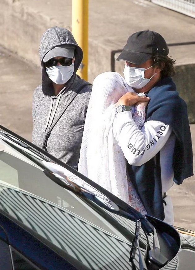 PHOTO: Katy Perry and Orlando Bloom hide from paparazzi at the airport