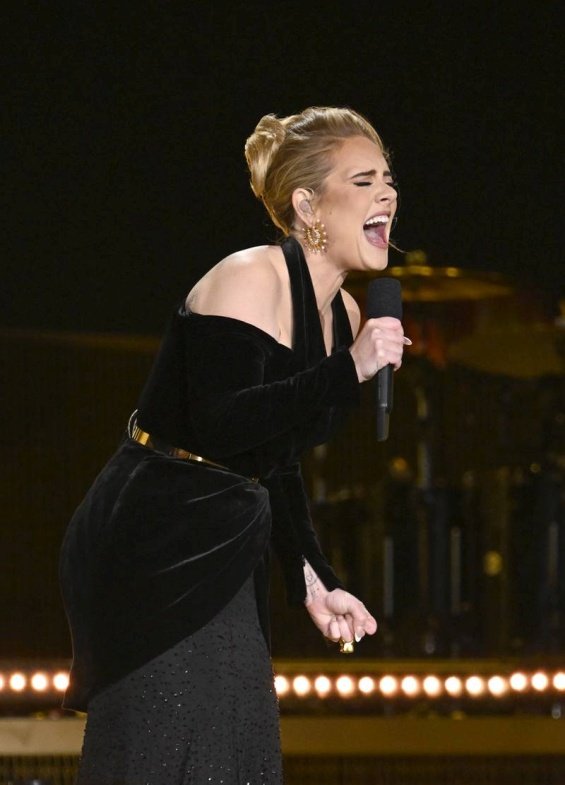 Adele in a black creation that accentuates her figure at a concert in London